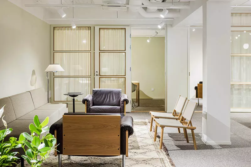 Modernisti sohvalla ja nojatuoleilla kalustettu neuvottelutila Bensowin talossa